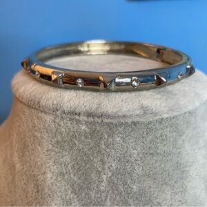 Hinged silver tone bangle bracelet with dog collar spikes and clear glass